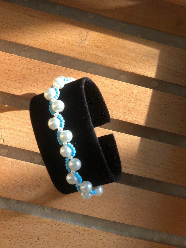 Handmade pearl and turquoise seed bead bracelet on black velvet bracelet stand