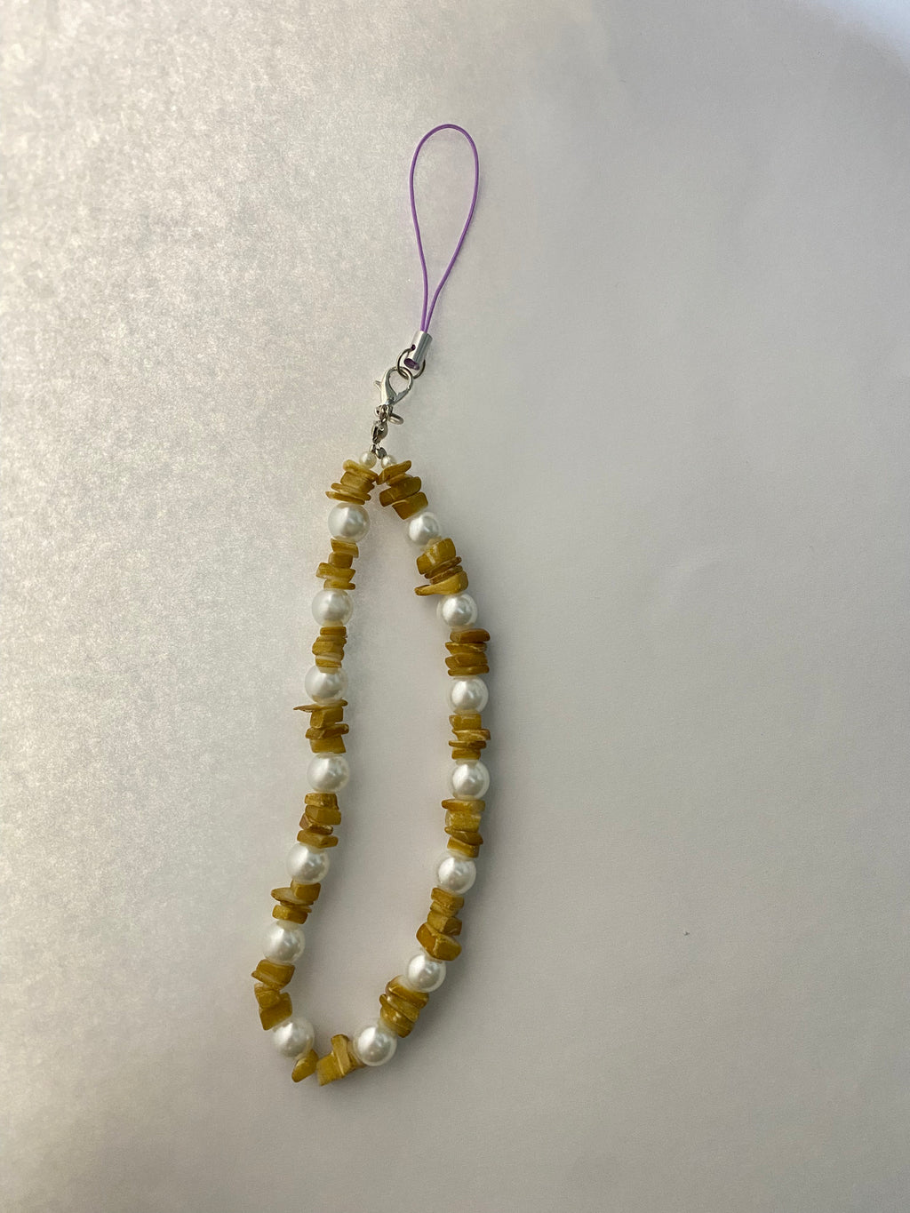 Phone charm with beads on a white background
