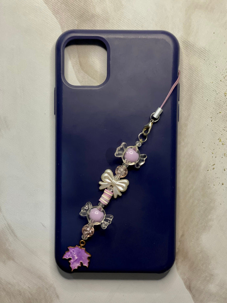 Close-up of clear candy charm and pearl bow on coquette phone strap
