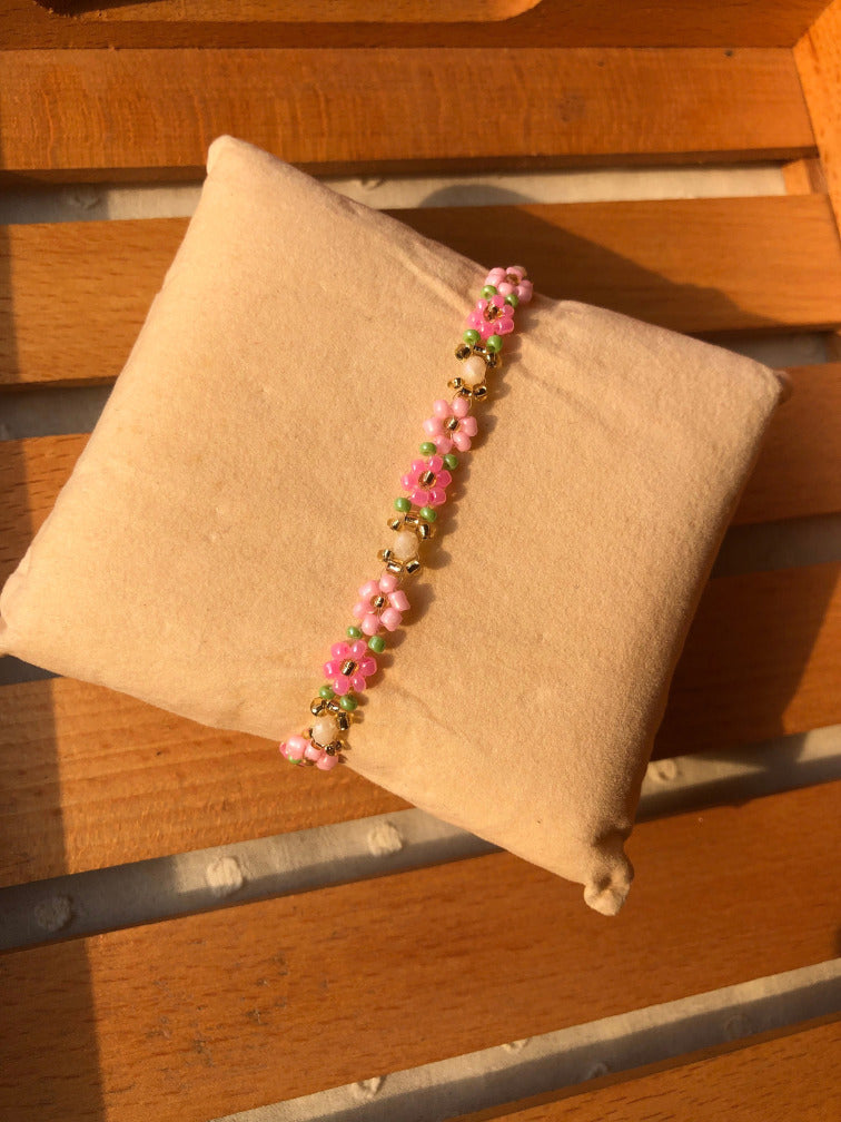 Handmade hot pink daisy seed bead bracelet on bright green base with gold accents